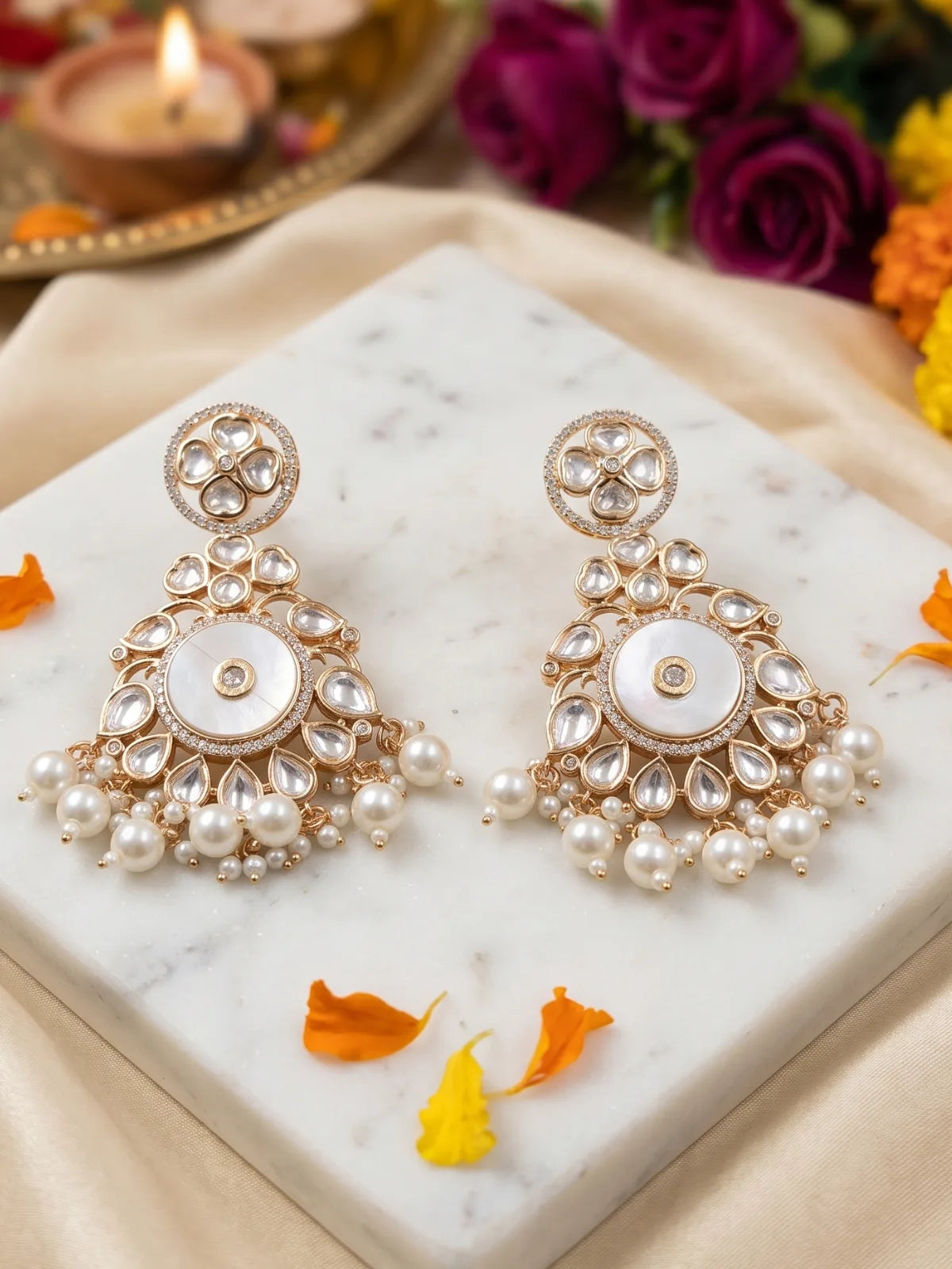 White Kundan Chandbali earrings featuring a luminous mother of pearl centre, circular floral stonework and multiple pearl danglers.