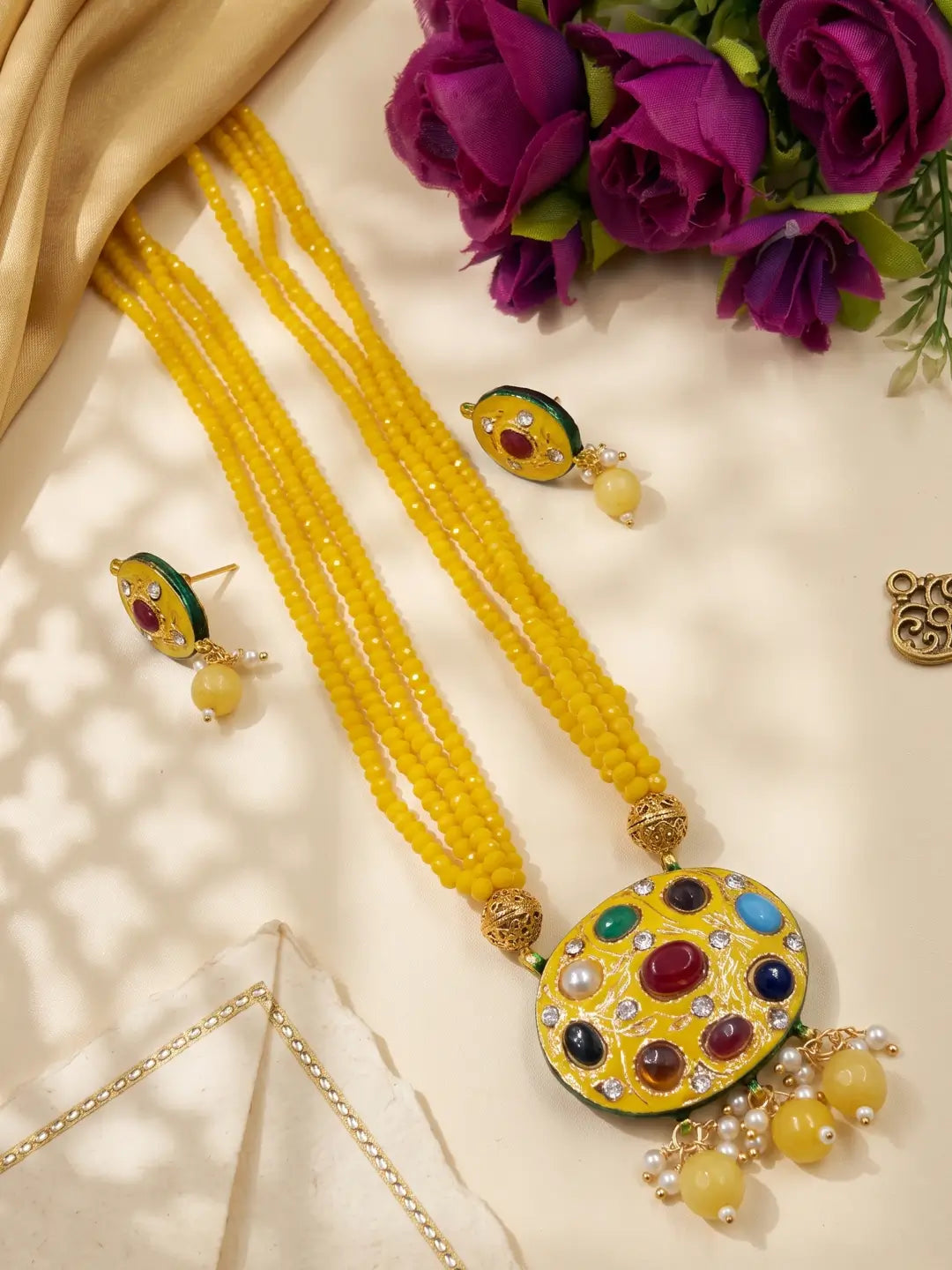 yellow layered bead necklace with a decorative multicolour Navratna pendant and coordinated stud earrings.
