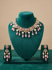 traditional gold plated pink kundan necklace set with pink beaded drops on a green velvet mannequin.