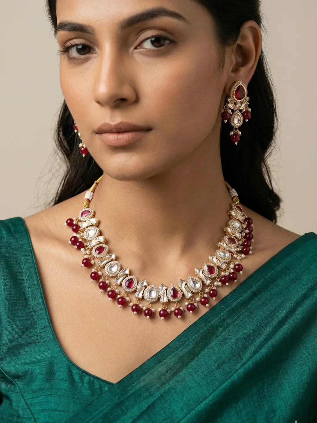 a women wearing and Elegant Beaded Kundan necklace set featuring handcrafted Ruby And Kundan stones, delicate pearl drops, and matching earrings, perfect for bridal wear, weddings, festive occasions, and traditional Indian jewellery.