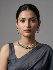 a women wearing an Elegant Beaded Kundan necklace set featuring handcrafted emerald And Kundan stones, delicate pearl drops, and matching earrings, perfect for bridal wear, weddings, festive occasions, and traditional Indian jewellery.