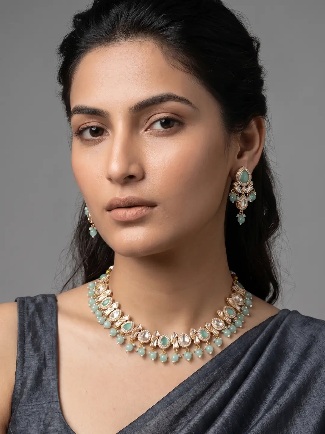 a women is wearing an elegant Beaded Kundan  necklace set featuring handcrafted mint green stones And Kundan stones, delicate pearl drops, and matching earrings, perfect for bridal wear, weddings, festive occasions, and traditional Indian jewellery.