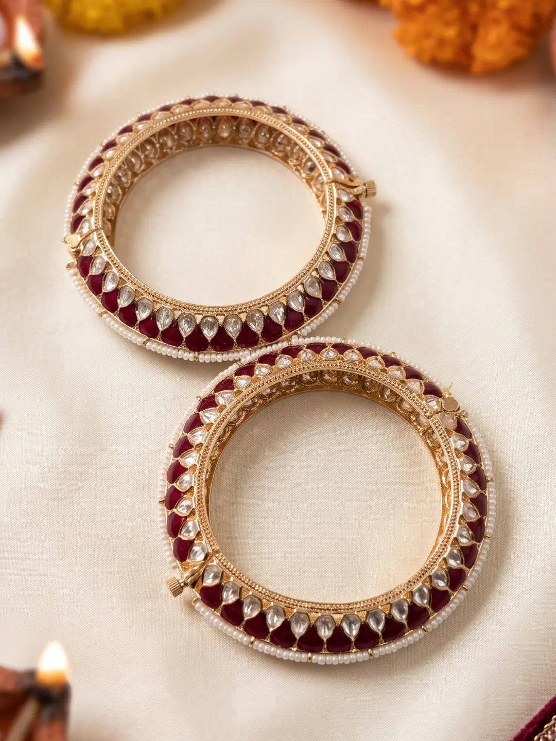 Handcrafted gold-plated Kundan bangles featuring sparkling Kundan stones, elegant pearl borders, and ruby red enamel detailing, perfect for bridal wear, weddings, festive occasions, and traditional Indian jewellery.