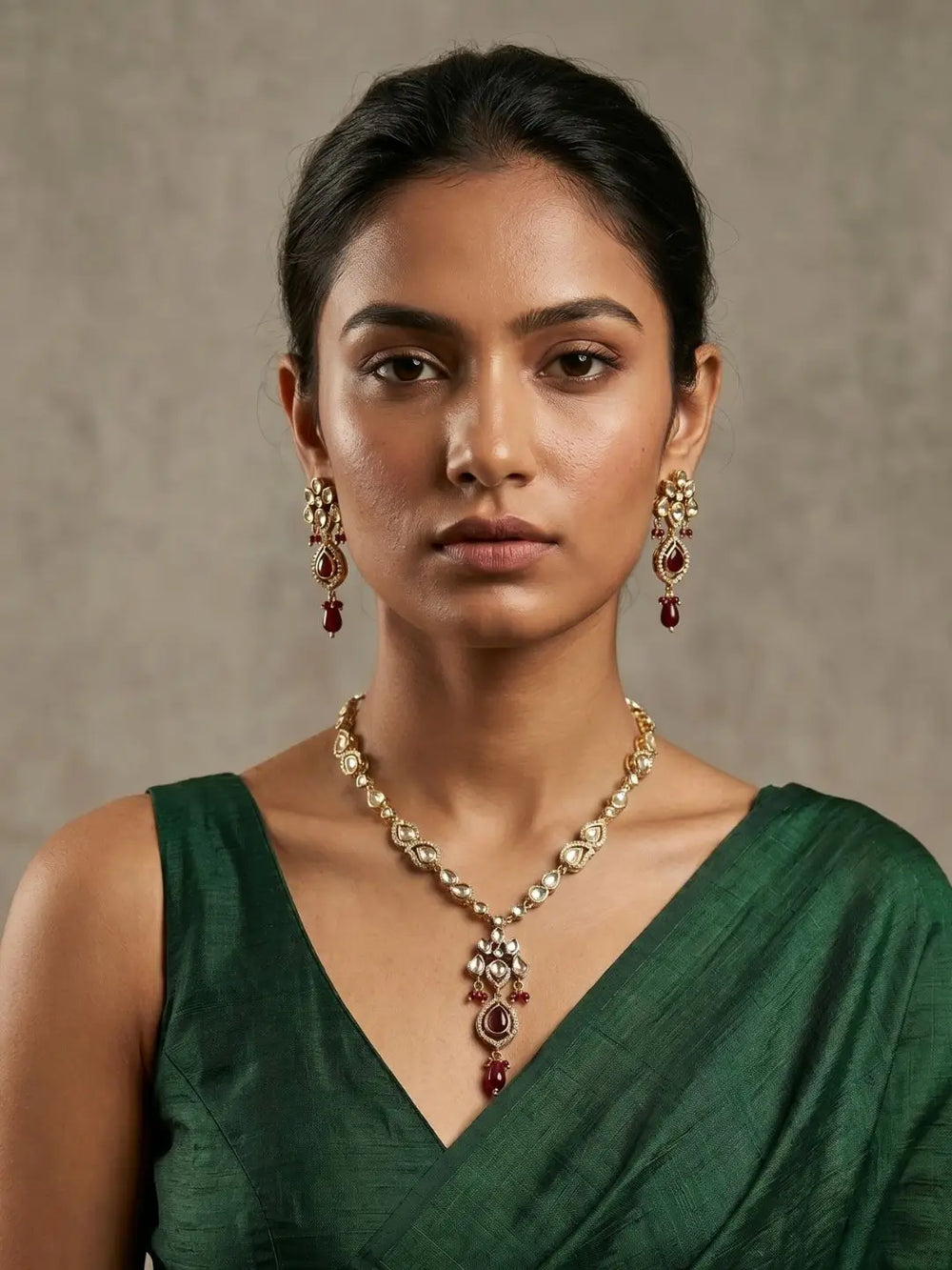 a women in a green daree is wearinh an elegant gold-plated Kundan pendant necklace set with polki drop pendant and matching earrings, handcrafted traditional Indian jewellery for weddings, festive occasions, party wear, and ethnic outfits.