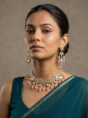 a women wearing an Elegant Pink Kundan necklace set with matching chandelier earrings featuring premium Kundan stones, Pink bead drops, and gold-tone finish, perfect for bridal wear, weddings, festive occasions, and traditional Indian jewellery.
