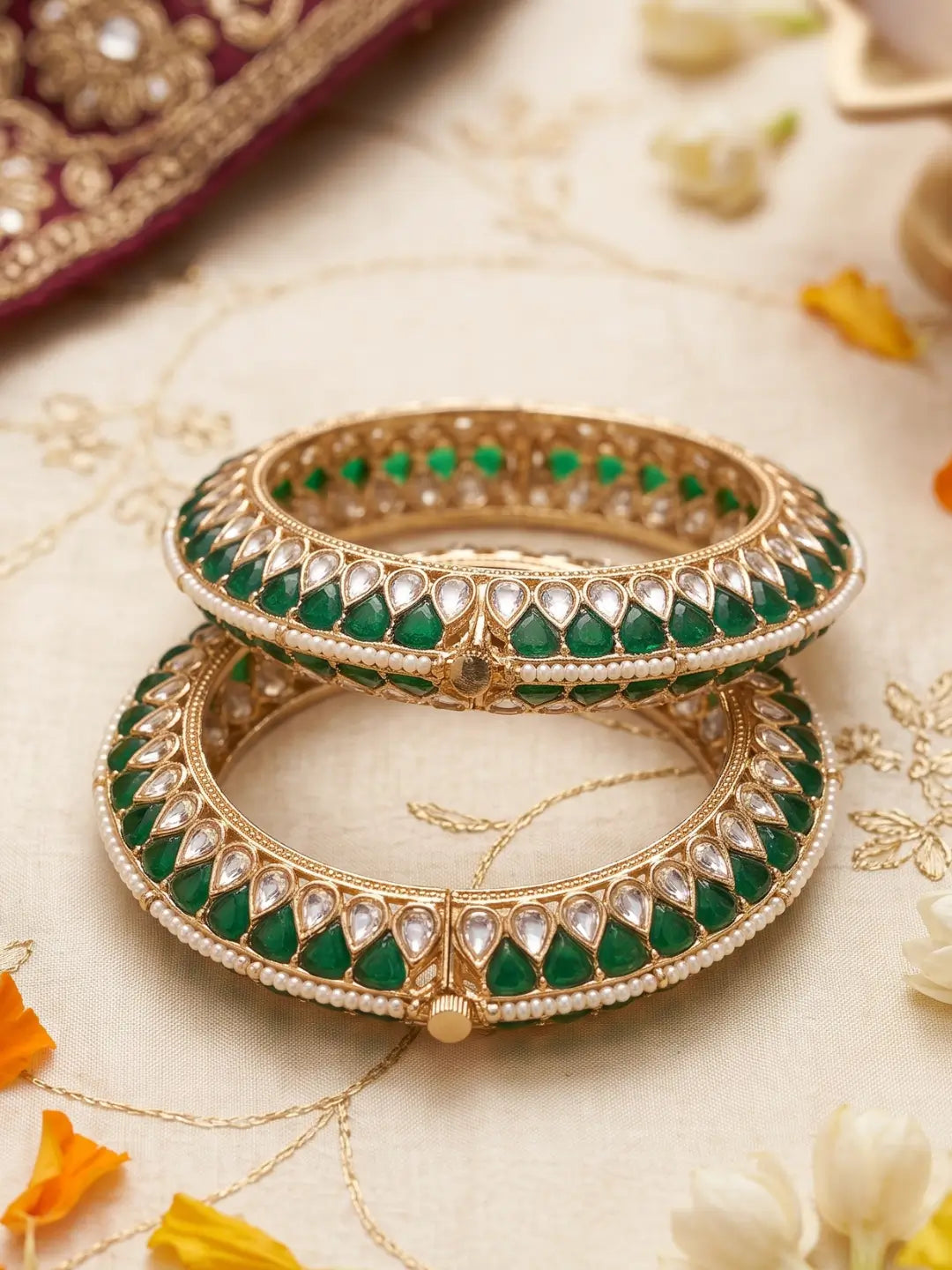 Handcrafted gold-plated Kundan bangles featuring sparkling Kundan stones, elegant pearl borders, and emerald green enamel detailing, perfect for bridal wear, weddings, festive occasions, and traditional Indian jewellery.