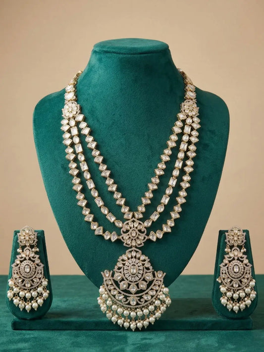 Long layered polki Jewelry set with necklace and earrings on a green stand against a beige background