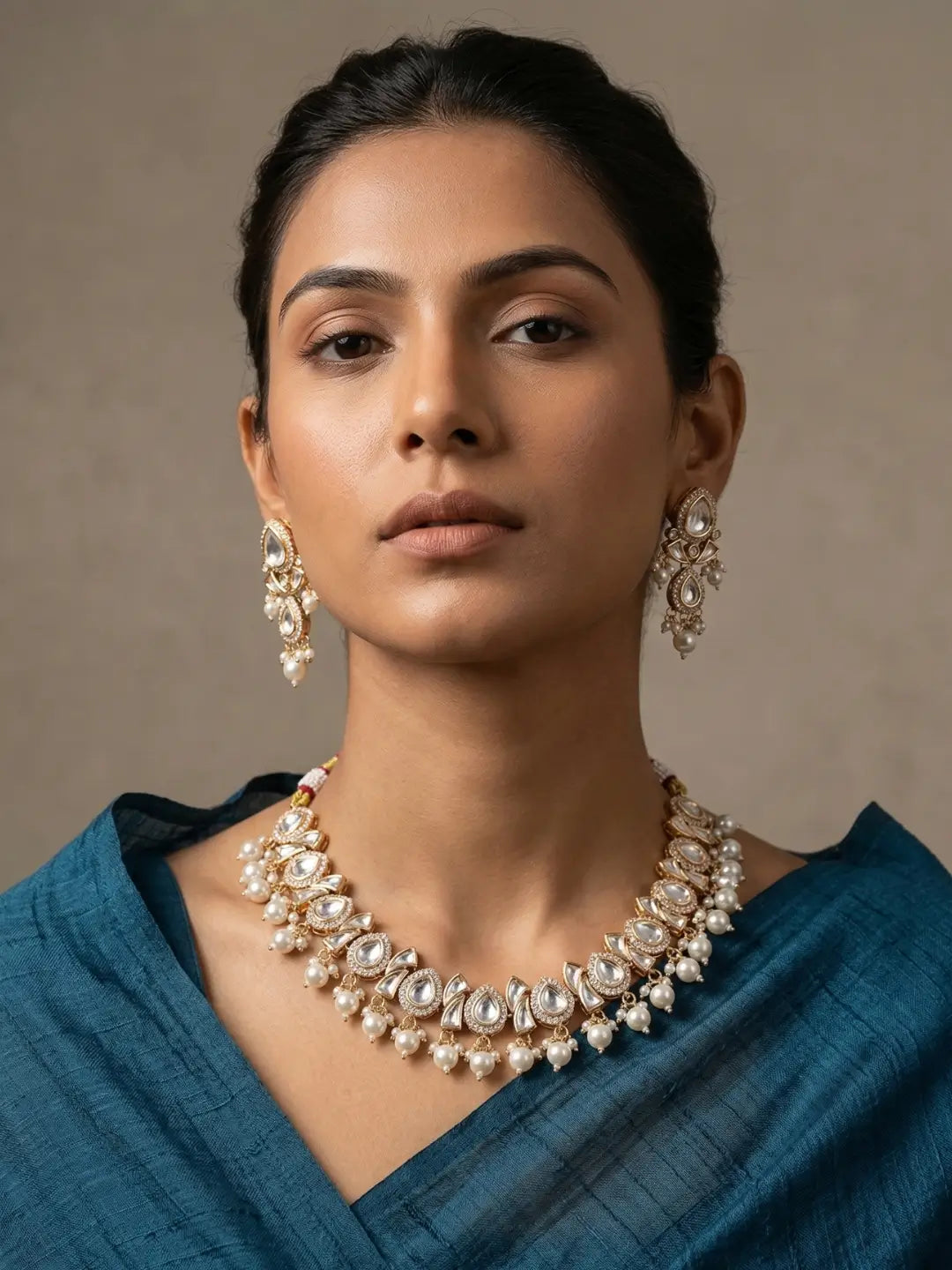 A womwen wearing an elegant Beaded Kundan necklace set featuring handcrafted pearls And Kundan stones, delicate pearl drops, and matching earrings, perfect for bridal wear, weddings, festive occasions, and traditional Indian jewellery.