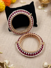 Handcrafted gold-plated Kundan bangles featuring sparkling Kundan stones, elegant pearl borders, and ruby red enamel detailing, perfect for bridal wear, weddings, festive occasions, and traditional Indian jewellery.