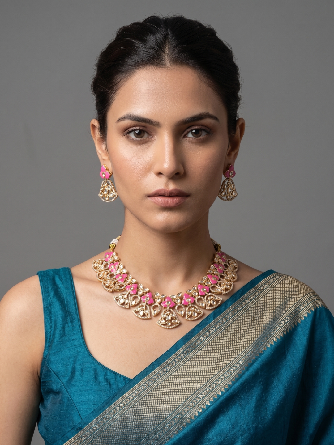 A women is wearing a handcrafted gold-plated floral Kundan necklace set with matching earrings featuring Polki, CZ stones and  pink enamel accents, ideal for bridal wear, weddings, festive occasions, and traditional Indian jewellery.