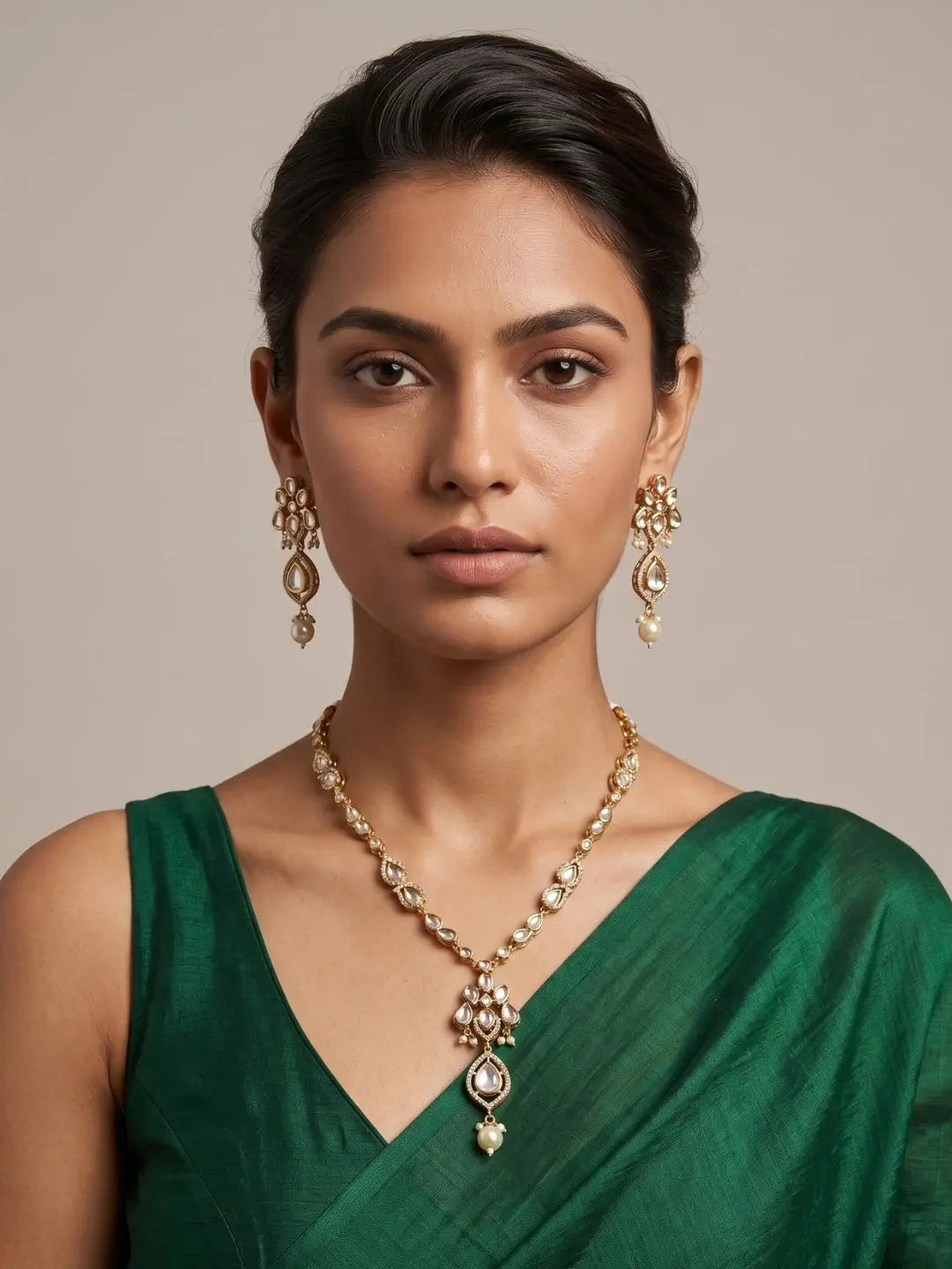 a women wearing an elegant gold-plated Kundan pendant necklace set with polki drop pendant and matching earrings, handcrafted traditional Indian jewellery for weddings, festive occasions, party wear, and ethnic outfits.
