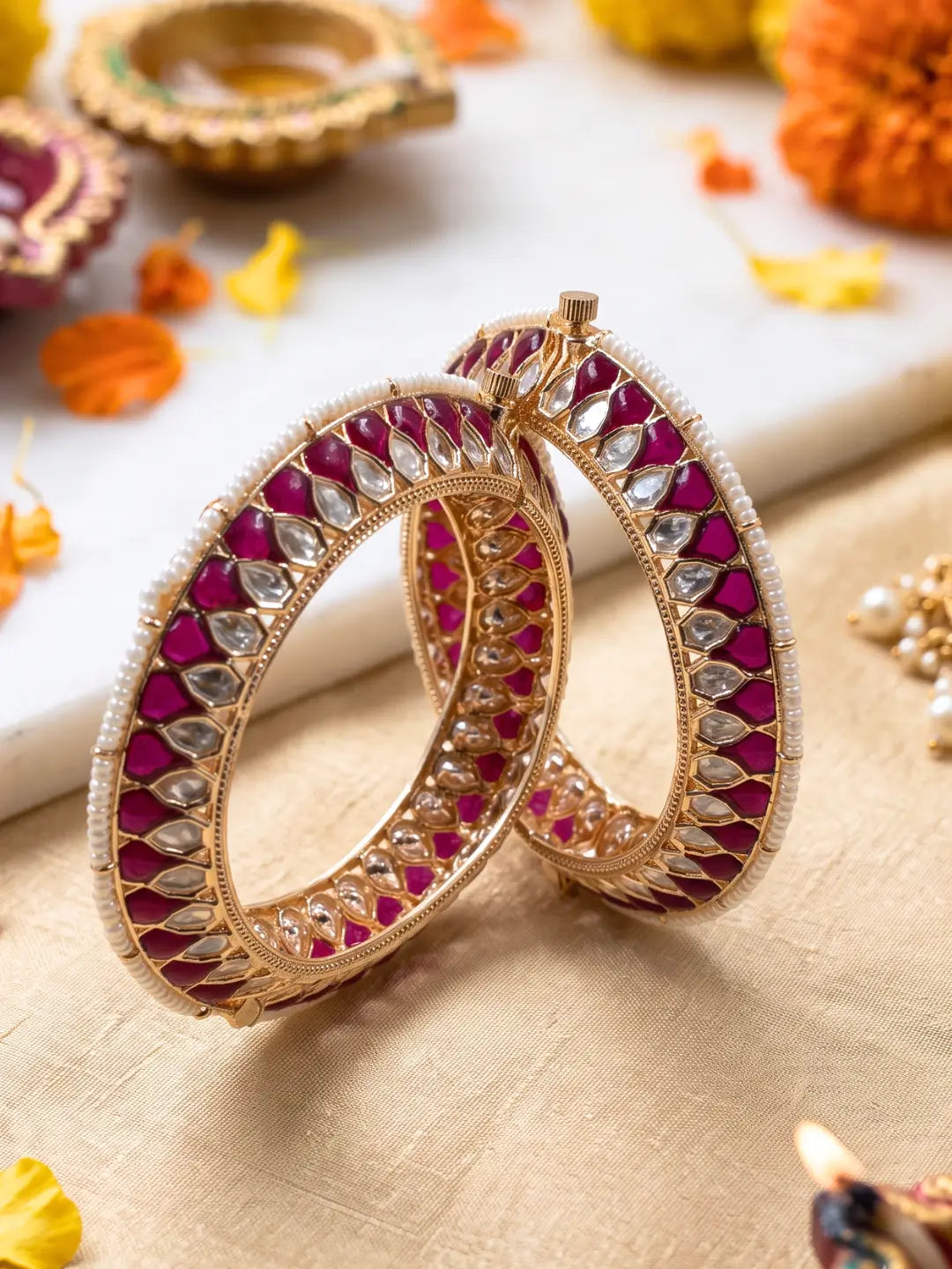 Handcrafted gold-plated Kundan bangles featuring sparkling Kundan stones, elegant pearl borders, and ruby red enamel detailing, perfect for bridal wear, weddings, festive occasions, and traditional Indian jewellery.