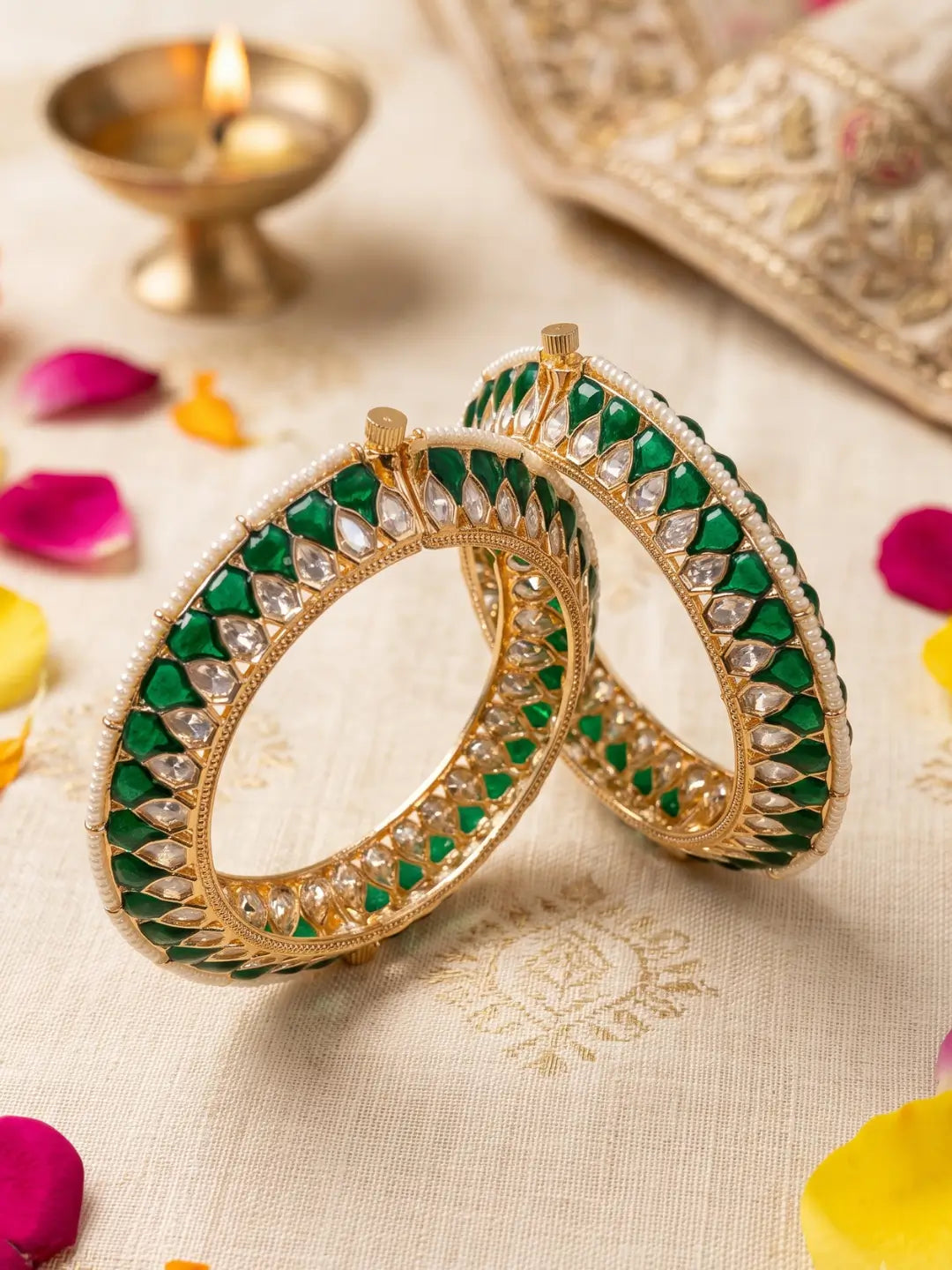 Handcrafted gold-plated Kundan bangles featuring sparkling Kundan stones, elegant pearl borders, and emerald green enamel detailing, perfect for bridal wear, weddings, festive occasions, and traditional Indian jewellery.