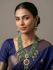 a women wearing a blue saree with Handcrafted emerald green multi-layer beaded long necklace featuring an elegant Kundan pendant with matching earrings, perfect for bridal wear, weddings, festive celebrations, and traditional Indian jewellery.
