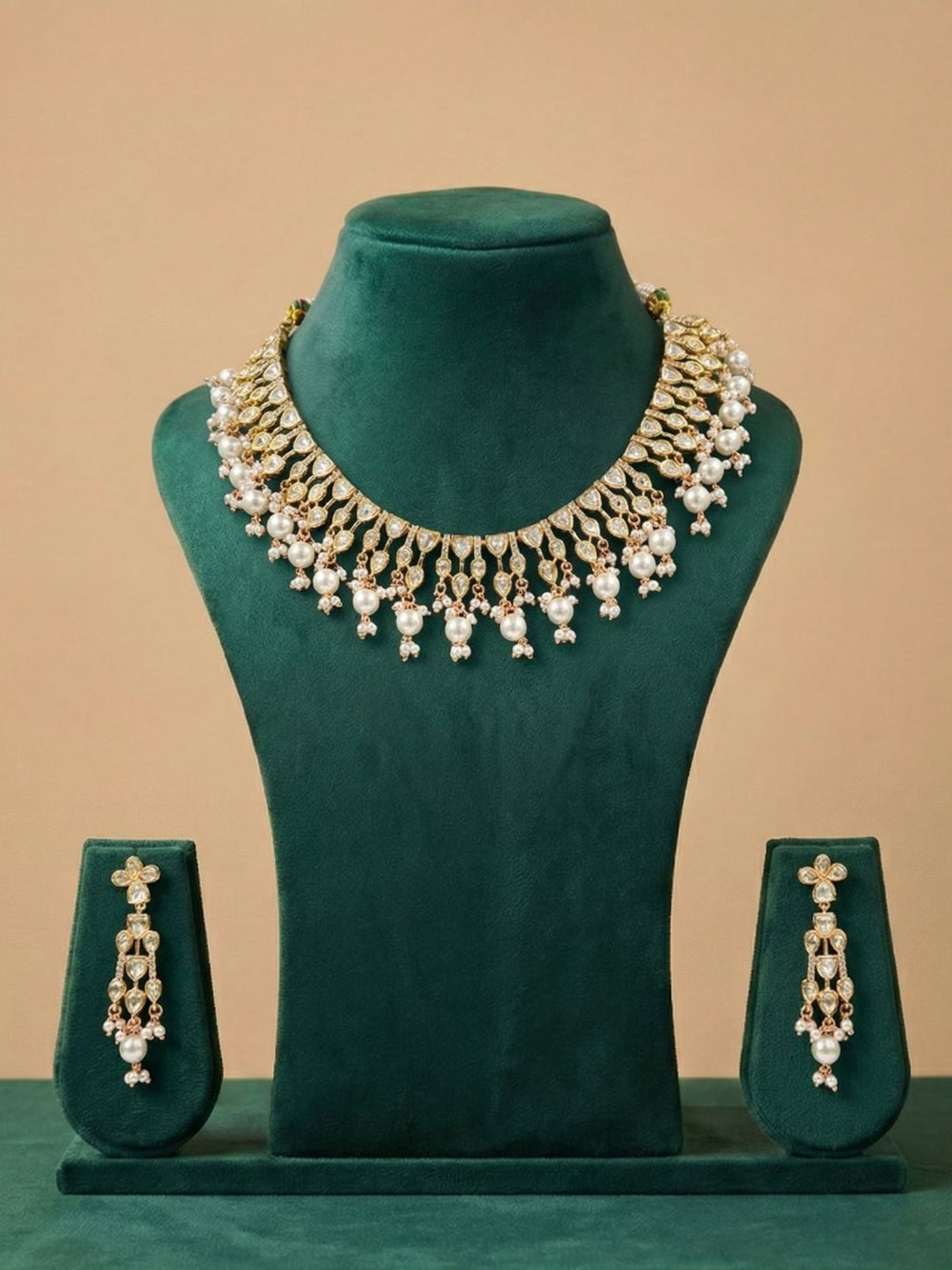 polki kundan and pearl necklace with matching earrings on a green mannequin against a beige background