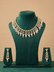 polki kundan and pearl necklace with matching earrings on a green mannequin against a beige background