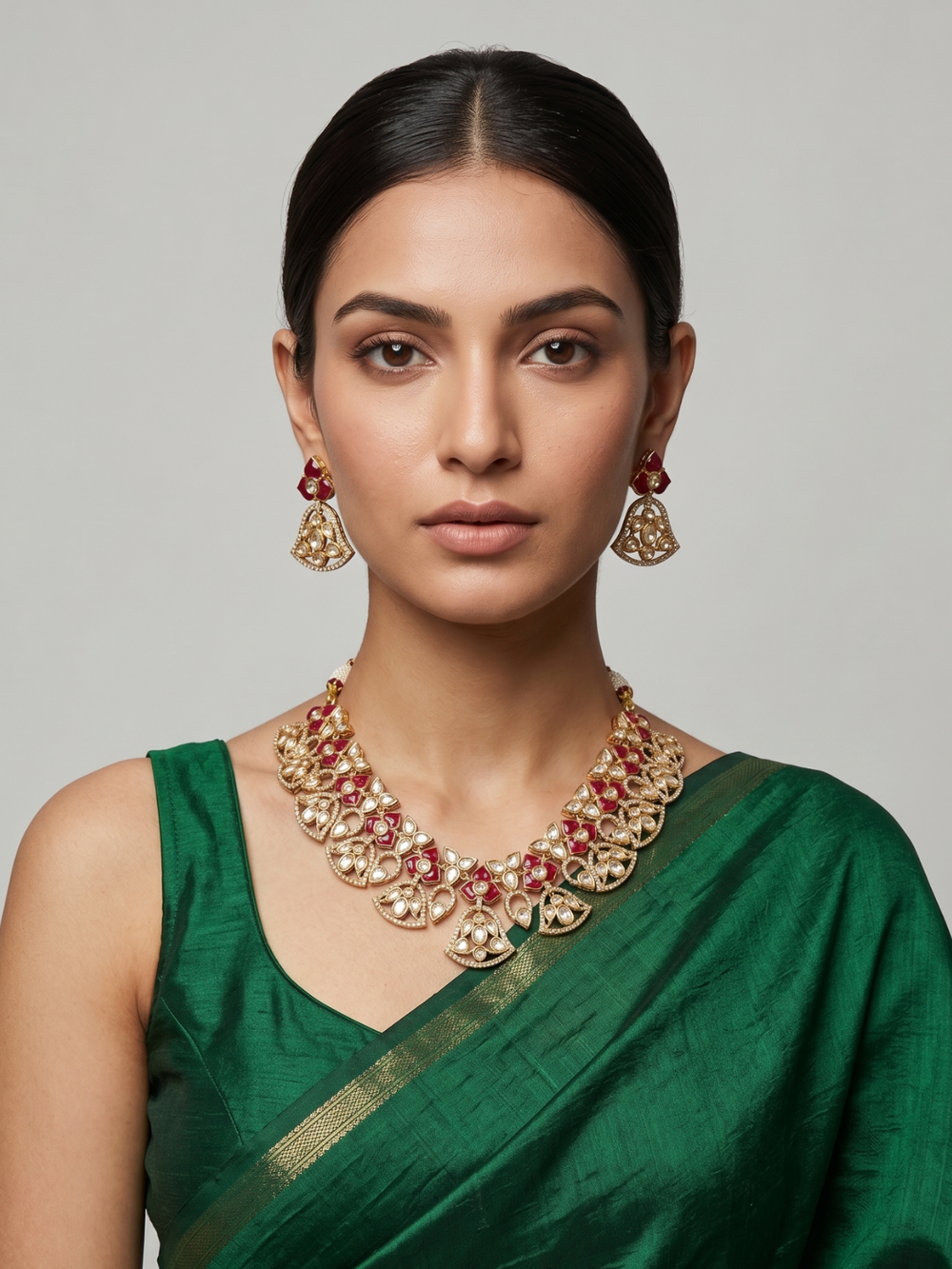 A women is wearing a handcrafted gold-plated floral Kundan necklace set with matching earrings featuring Polki, CZ stones and  ruby red accents, ideal for bridal wear, weddings, festive occasions, and traditional Indian jewellery.
