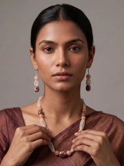 women wearing an Elegant White Rainbow Moonstone And Brown Chalcedony Gemstones Beaded Necklace Set on a brown saree